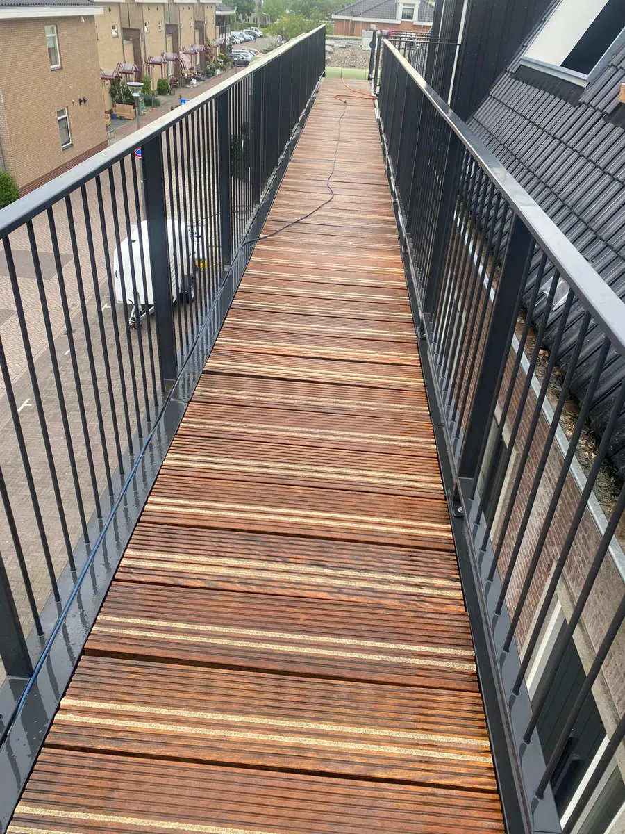 Houten loopbrug na reiniging, het hout weer diep van kleur
